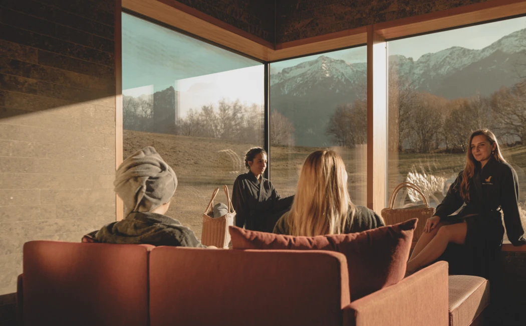 Entspannte Gäste im Wellnessbereich des Hotels Klosterhof, mit Blick auf die Alpenlandschaft in Bayern.