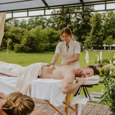 Eine Person erhält eine entspannende Massage im Wellnessbereich des Hotel Klosterhof, umgeben von schöner Natur in Bayern.
