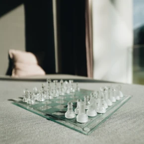 Schachbrett mit klaren Figuren auf einem Tisch im Hotel Klosterhof, umgeben von natürlichem Licht und einem gemütlichen Ambiente.