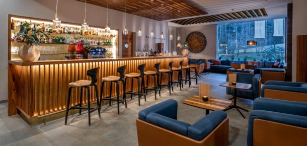 Moderne Bar im Hotel Klosterhof, mit stilvollen Sitzgelegenheiten und einer Auswahl an Getränken, umgeben von eleganter Atmosphäre.