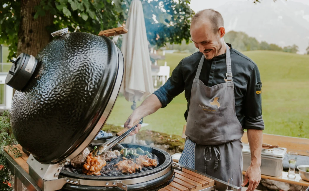 Chef grilling meat outdoors at Hotel Klosterhof.
