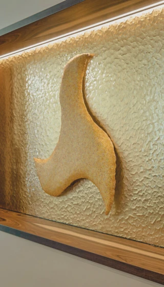 Artistic sculpture on textured wall at Wellnesshotel Klosterhof in Bayern.