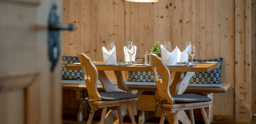 Gemütlicher Essbereich mit Holzmobiliar, eleganter Tischdekoration und warmem Licht, ideal für ein entspanntes Dinner.