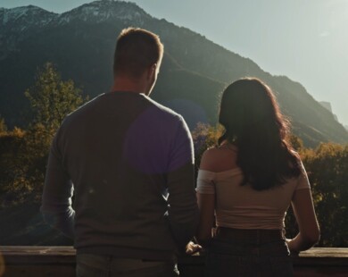 Ein Paar steht auf dem Balkon ihres Hotelzimmers und genießt den Ausblick auf die Bergwelt im Berchtesgadener Land.