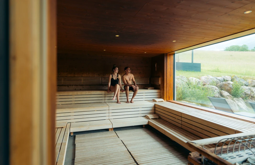 Junges Pärchen beim gemeinsamen Baden im Indoor-Pool des romantischen Hotels Klosterhof in Bayern.