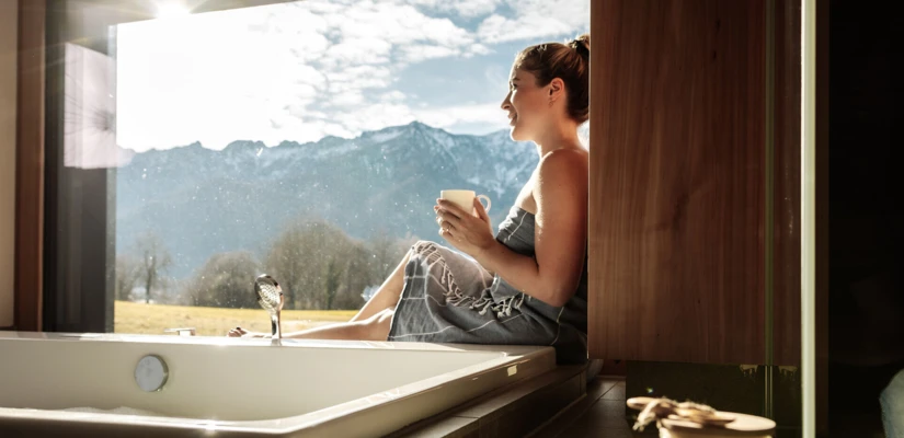 Junge Frau am Fenster im Spa Loft mit Whirlpool im Wellnesshotel Klosterhof in Bayern