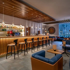 Moderne Bar im Hotel Klosterhof mit eleganter Holzdecke und stilvollen Sitzbereichen, ideal f&uuml;r entspannte Abende in Bayerisch Gmain.