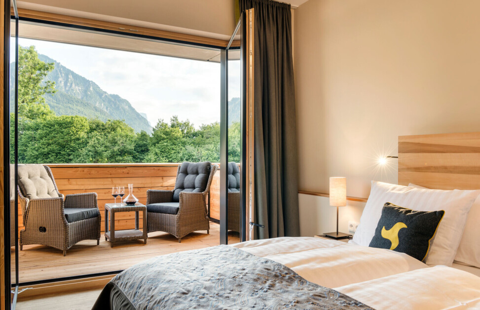 Doppelzimmer mit Balkon und Sitzmöglichkeit im 4 Sterne Superior Designhotel Klosterhof in Bayern.