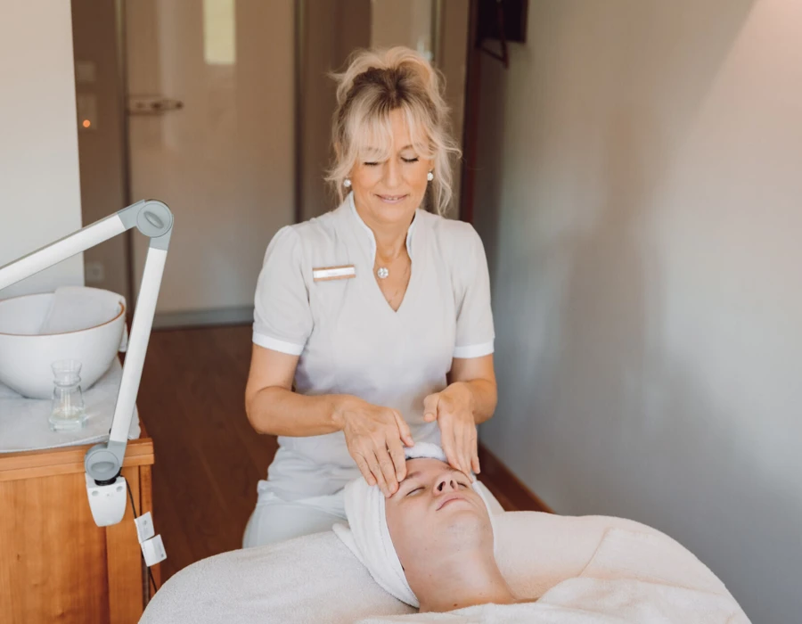 Eine Kosmetikerin führt eine entspannende Gesichtsmassage in einem Spa durch.