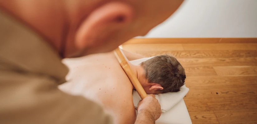 Masseur bei einer entspannenden Bambus-Massage im Spahotel Klosterhof in Bayern.