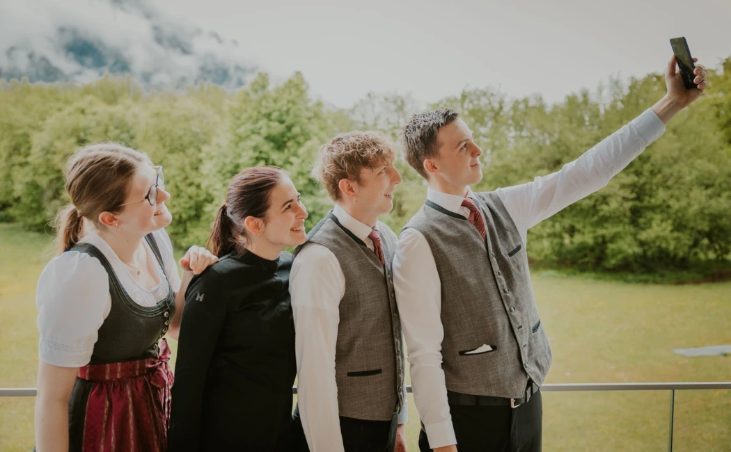 Eine Gruppe junger Menschen macht ein Selfie vor einer grünen Landschaft, passend zum entspannten Ambiente des Hotel Klosterhof.