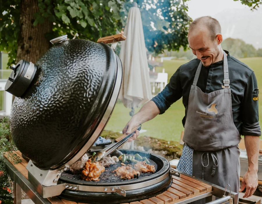 Chef grilling meat outdoors at Hotel Klosterhof.