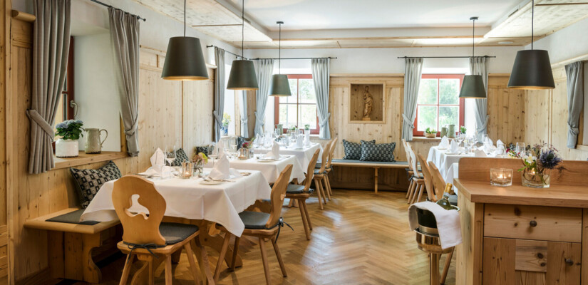 Gemütliche Stube mit gedeckten Tischen im Restaurant des Hotel Klosterhof, Bayern.