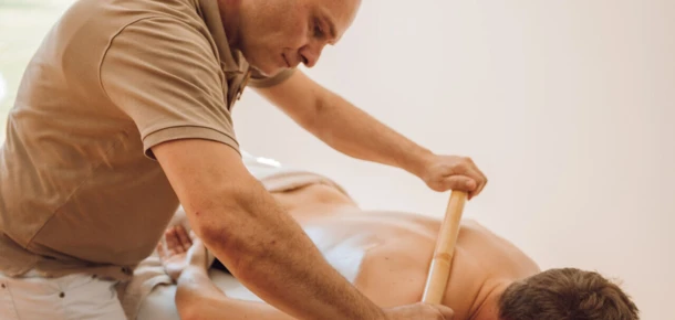 Spa therapist performing a bamboo massage on a guest at Wellnesshotel Klosterhof.
