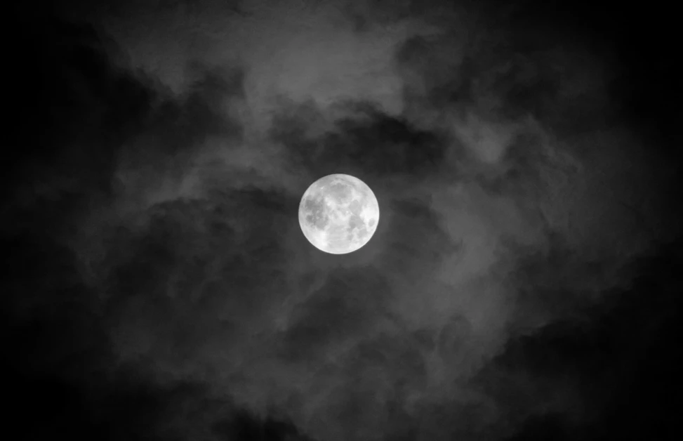 Der Mond leuchtet hell zwischen dunklen Wolken über dem Hotel Klosterhof in Bayerisch Gmain, ideal für entspannende Nächte.