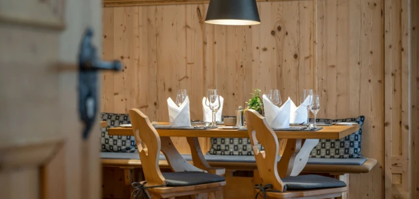 Gemütlicher Essbereich mit Holzmobiliar, eleganter Tischdekoration und warmem Licht, ideal für ein entspanntes Dinner.