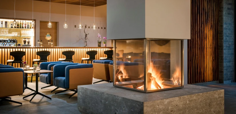 Gemütlicher Lounge-Bereich im Hotel Klosterhof mit modernem Design, zentralem Kamin und stilvollem Barbereich in Bayerisch Gmain.