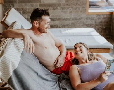 Junges Pärchen beim gemeinsamen Baden im Indoor-Pool des romantischen Hotels Klosterhof in Bayern.