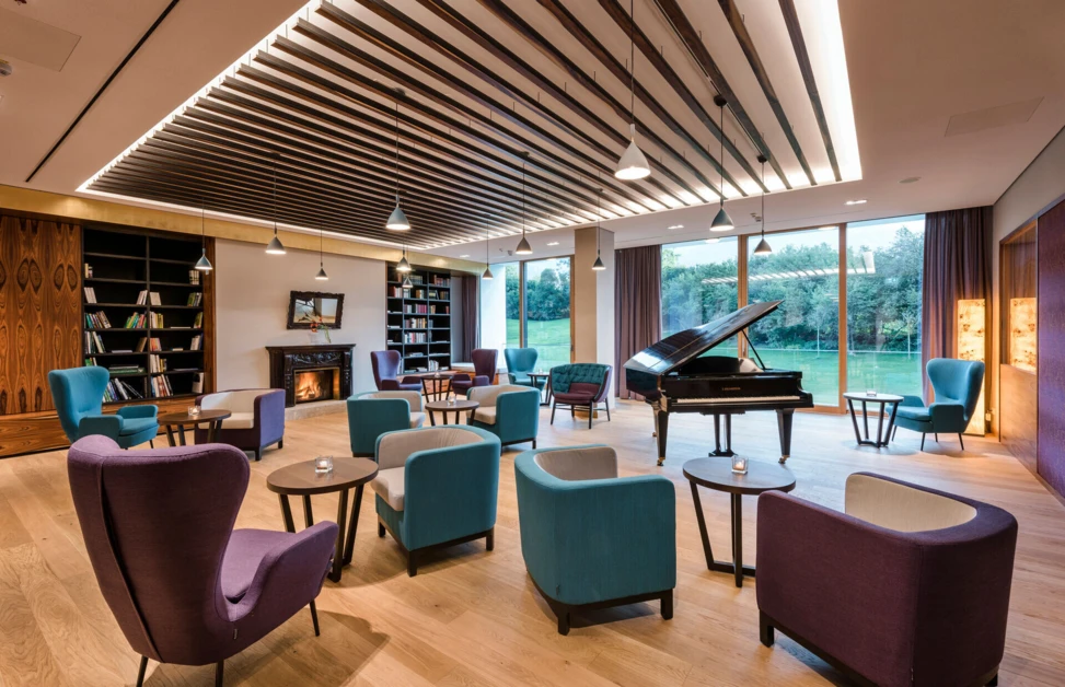Gemütliche Sitzmöglichkeiten mit Panoramablick in der Bibliothek des Designhotel Klosterhof in Bayern.