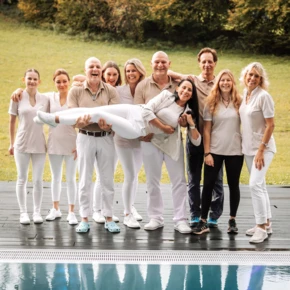 Gruppenfoto des Teams vom Hotel Klosterhof, umgeben von Natur und einem Pool, strahlende Gesichter in entspannter Atmosphäre.