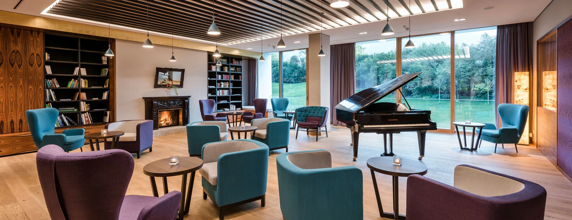 Gemütliche Sitzmöglichkeiten mit Panoramablick in der Bibliothek des Designhotel Klosterhof in Bayern.