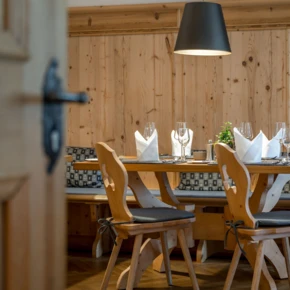 Gemütlicher Essbereich mit Holzmobiliar, eleganter Tischdekoration und warmem Licht, ideal für ein entspanntes Dinner.