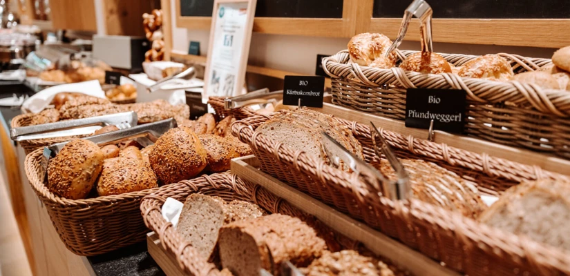 Ein Buffet mit verschiedenen Brotsorten in Körben, perfekt für das Frühstück im Hotel Klosterhof, Bayern.