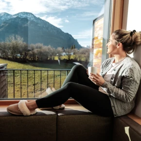 Frau sitzt am Fenser der Private Spa Suite im Hotel Klosterhof in Bayern