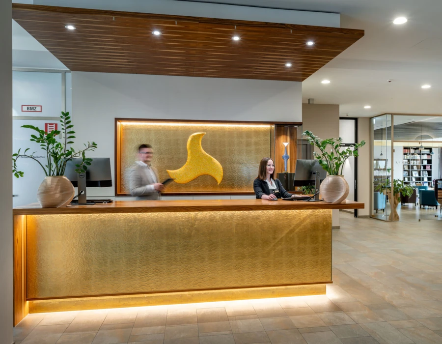 Rezeption des Hotel Klosterhof mit freundlichem Personal und modernen Designelementen in einem einladenden Ambiente.
