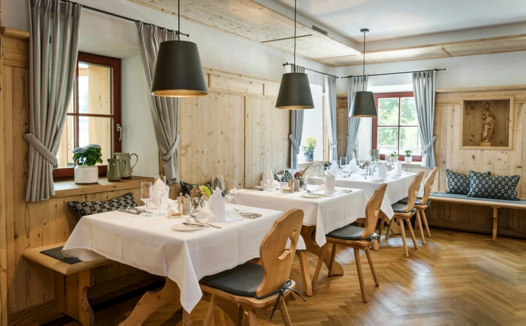 Cozy restaurant with wooden interior, neatly set tables, and natural light from large windows.