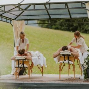 Junge Dame im Whirlpool mit Rosenbl&auml;ttern und Blick aus dem Panoramafenster im Hotel Klosterhof, Bayern.