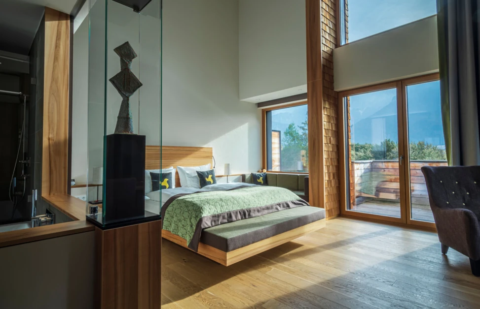 Helles, modernes Zimmer im Hotel Klosterhof mit Blick auf die Alpen und stilvollem Mobiliar. Ideal für Entspannung und Erholung.