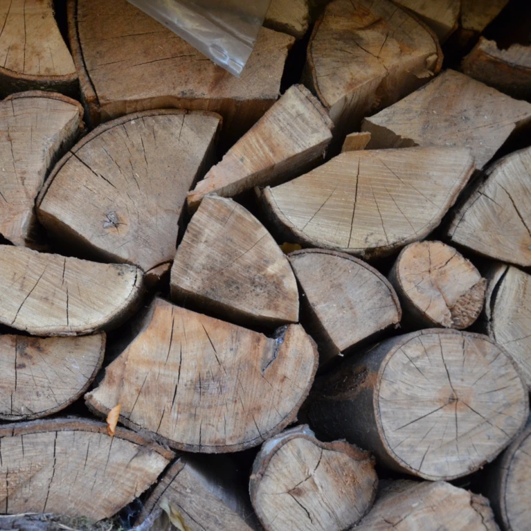 Ein Stapel von geschnittenem Holz, sorgfältig aufgeschichtet, ideal für den Kamin oder die Lagerung im Hotel Klosterhof.
