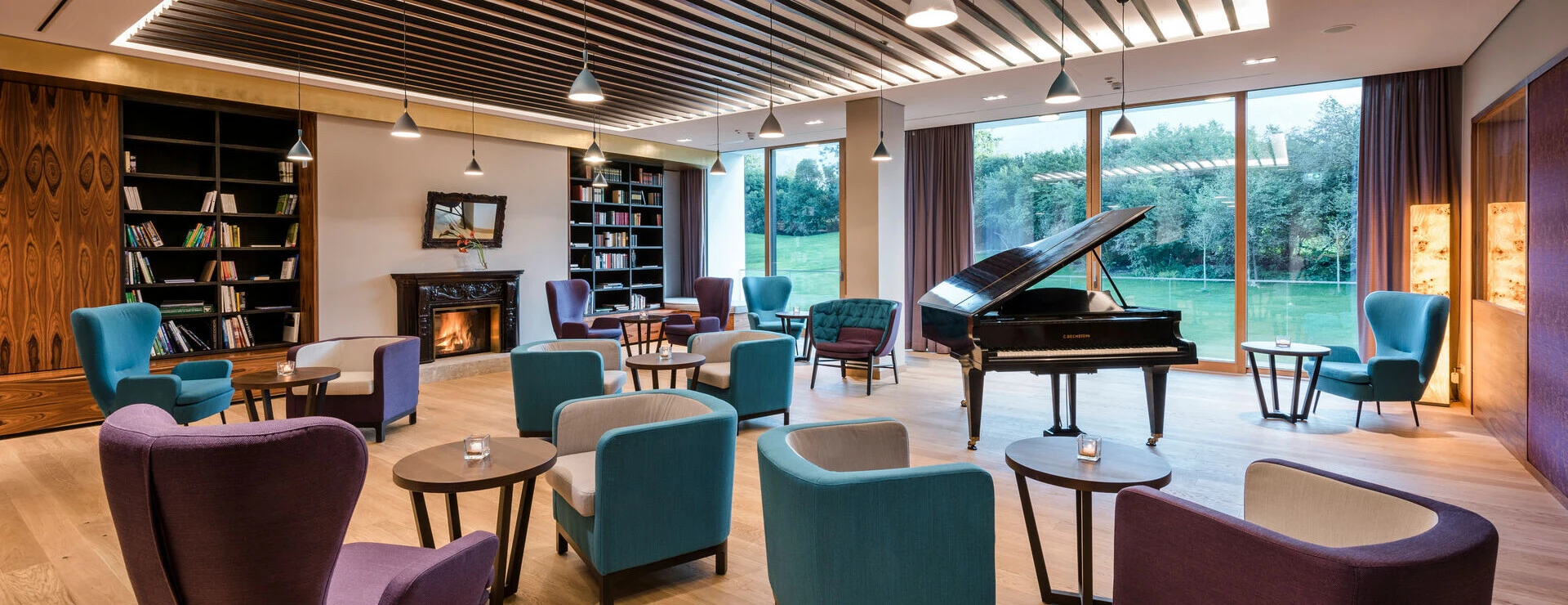 Gemütliche Sitzmöglichkeiten mit Panoramablick in der Bibliothek des Designhotel Klosterhof in Bayern.