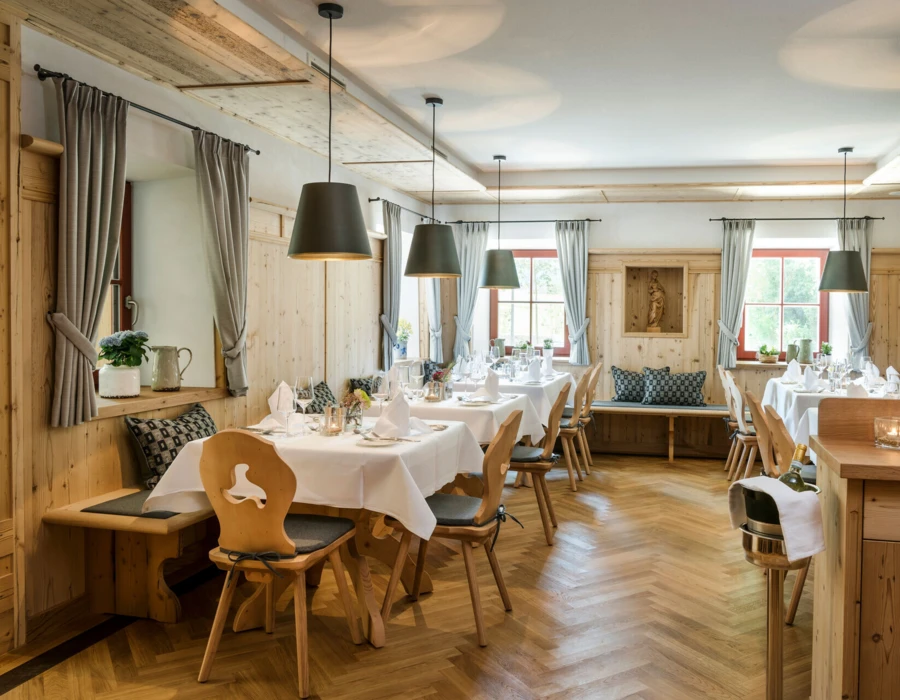 Gemütliche Stube mit gedeckten Tischen im Restaurant des Hotel Klosterhof, Bayern.