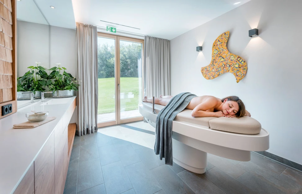 Eine entspannende Wellnessbehandlung in einem modernen Raum im Hotel Klosterhof, umgeben von natürlichem Licht und stilvoller Einrichtung.