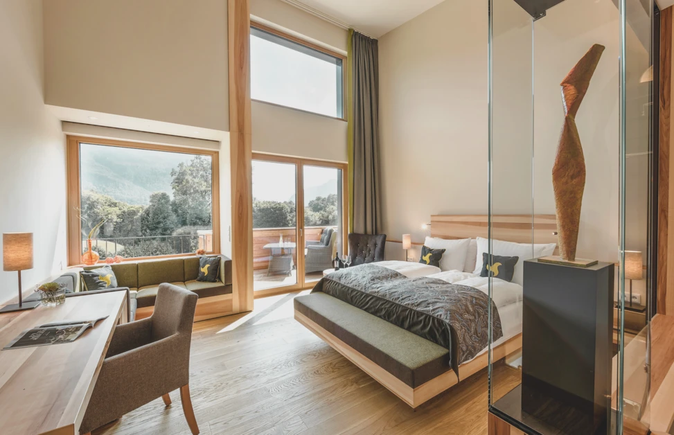 Helles und modernes Zimmer im Hotel Klosterhof mit Alpenblick, gemütlichem Sitzbereich und stilvoller Dekoration in Bayerisch Gmain.