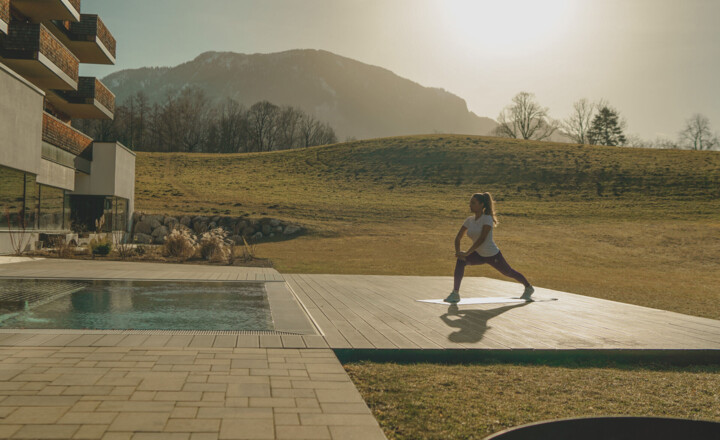 Dame beim Yoga am Außenpool im romantischen Wellnesshotel Klosterhof in Bayern.