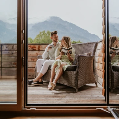 Paar entspannt sich auf der Terrasse des Wellnesshotels Hotel Klosterhof in Bayerisch Gmain, Bayern, mit Blick auf die Alpen.