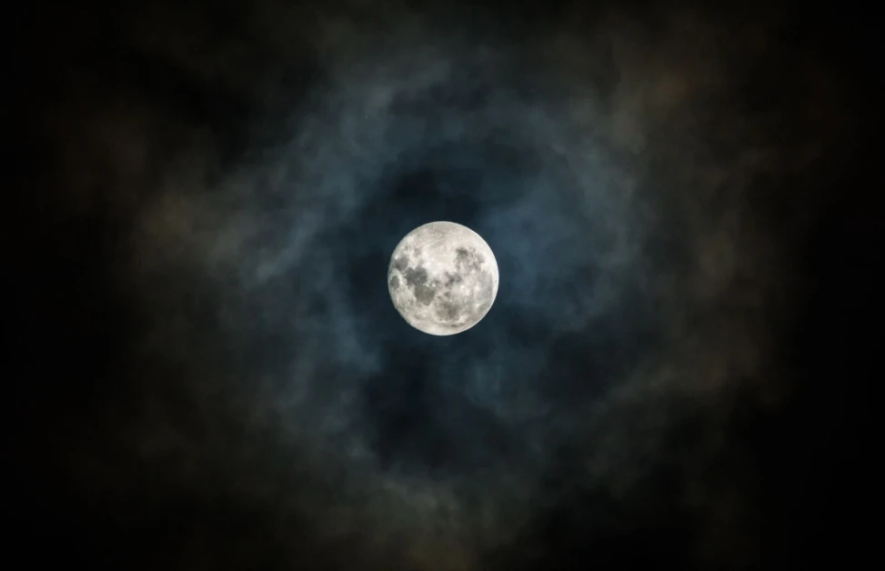 Der Mond leuchtet hell durch einen mystischen Wolkenring &uuml;ber Bayerisch Gmain.