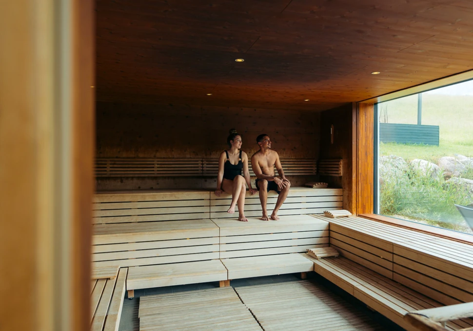 Junges Pärchen beim gemeinsamen Baden im Indoor-Pool des romantischen Hotels Klosterhof in Bayern.