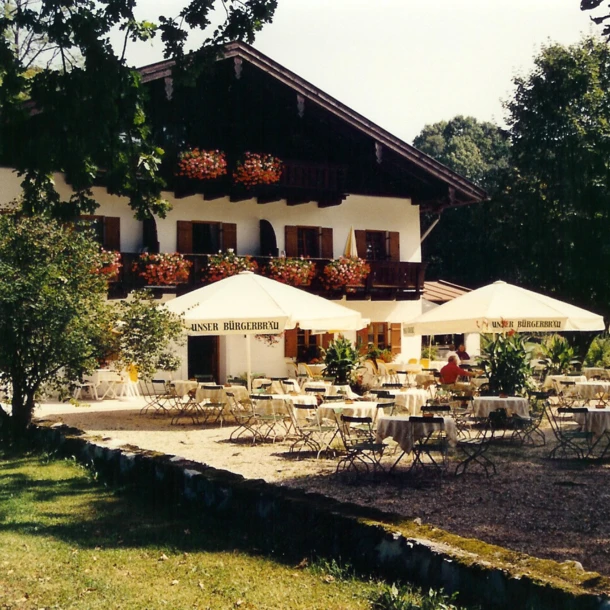 Ein einladendes Bild des Hotel Klosterhof mit Terrassenmöbeln und Sonnenschirmen in einer malerischen Umgebung in Bayern.