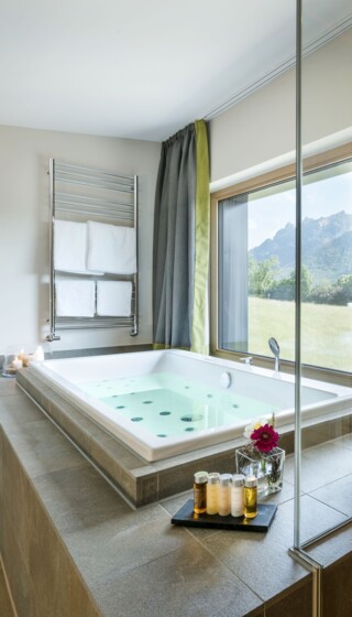 Whirlpool im Hotelzimmer mit Blick auf die umliegende Bergwelt in Bayern.