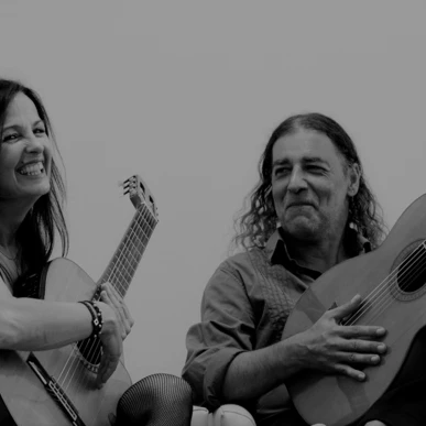 Zwei Musiker lächeln und spielen Gitarre in entspannter Atmosphäre im Hotel Klosterhof, einem Wellnesshotel in Bayern.