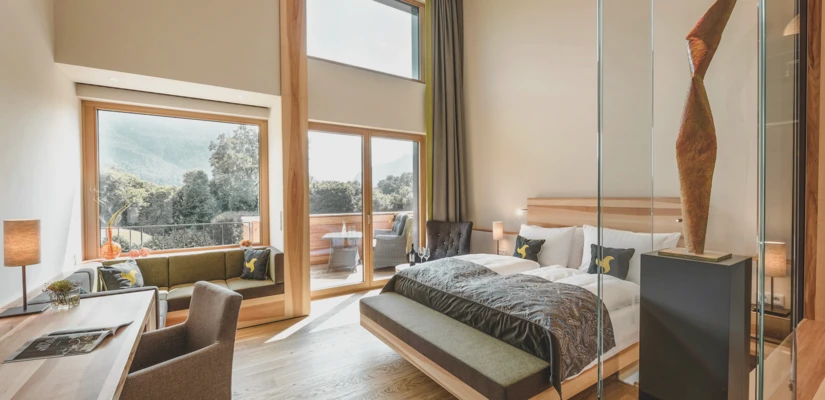 Helles und modernes Zimmer im Hotel Klosterhof mit Alpenblick, gemütlichem Sitzbereich und stilvoller Dekoration in Bayerisch Gmain.