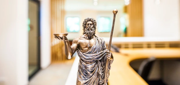 Eine Statue eines antiken Philosophen in einem modernen Innenraum, der eine entspannende Atmosphäre im Hotel Klosterhof vermittelt.