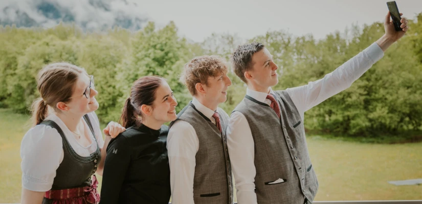 Eine Gruppe junger Menschen macht ein Selfie vor einer grünen Landschaft, passend zum entspannten Ambiente des Hotel Klosterhof.